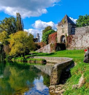 a person sitting on a bench next to a river