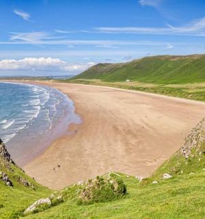 a view of a beach with the ocean and mountains
