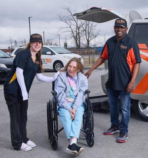 a woman in a wheelchair next to a man with a van