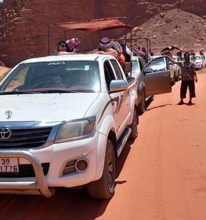 a group of people in the back of a truck in the desert