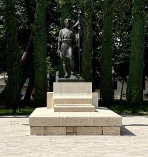 a statue of a man standing in a park