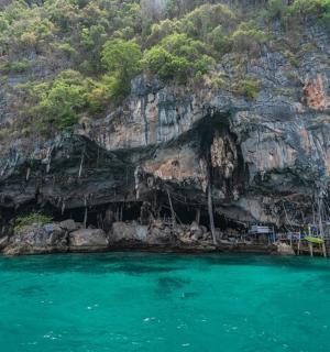 en hule i siden af et bjerg med blåt vand