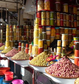 一名男子站在摆满食物的市场前