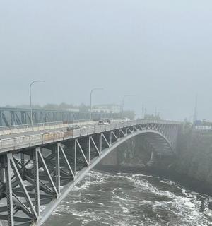 一座横跨水面、上面有汽车的桥