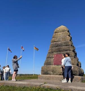 一群人站在纪念碑周围,手举旗帜