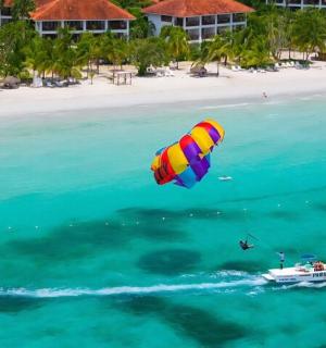 a person flying a kite over a boat in the ocean