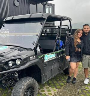 一名男子和一名女子站在一辆绿色吉普车旁