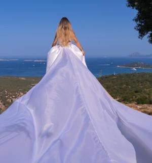 一位身穿白色连衣裙的女子站在山上