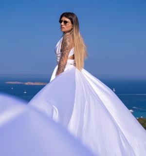 一位身穿白色连衣裙的女子站在山上