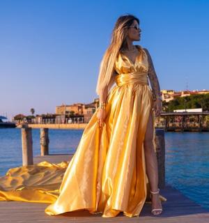 一位身穿黄色连衣裙的女士站在码头上