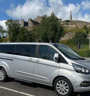 一辆银色货车停在停车场，背景是一座城堡