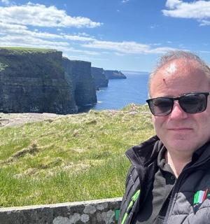 一名戴着墨镜的男子站在悬崖上