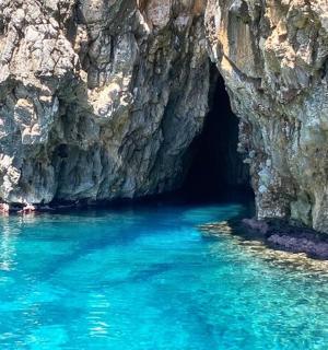 una grotta in una montagna con acqua blu
