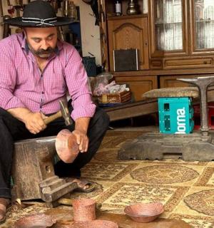 一位戴着牛仔帽的男子坐在桌子上工作