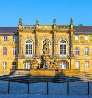 一座黄色的大楼，前面有一座喷泉