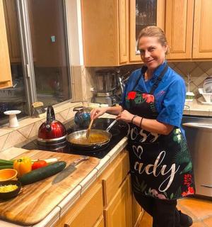 a woman standing in a kitchen preparing food