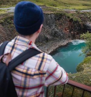 a man standing on a railing looking at a river
