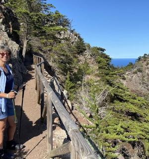 a woman standing on a trail on a mountain