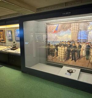 a man standing in front of a display case in a museum
