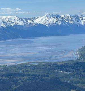 an aerial view of a lake with snow capped mountains