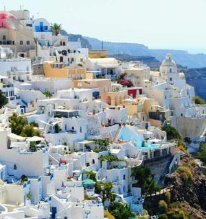 ett kluster av vita byggnader på sidan av ett berg