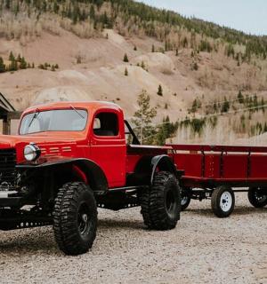 starý červený nákladní vůz zaparkovaný vedle budovy