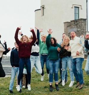 a group of people jumping in front of a building