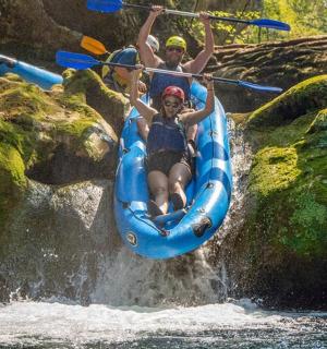 to personer på en tømmerflåde i et vandfald