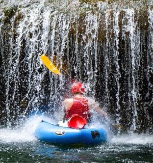 滝の前でいかだに乗っている男性