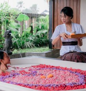 一位女士站在正在泡泡浴的小女孩旁边