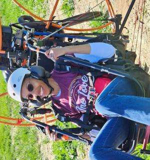 a woman is riding on a zip line in an amusement park