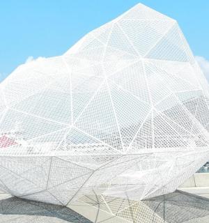 a large white sculpture is sitting on a sidewalk