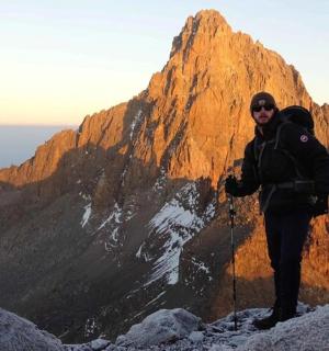 muž stojící na vrcholu hory