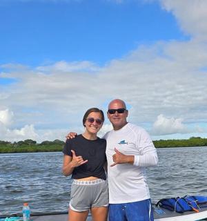 一男一女站在水上的桨板上