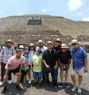 skupina lidí pózujících před pyramidou