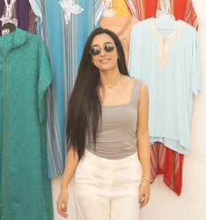 一位女士站在一些衣服前