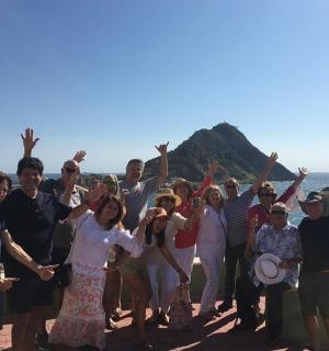 a group of people posing for a picture in front of the ocean