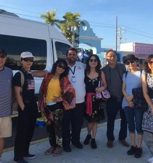 a group of people standing in front of a bus