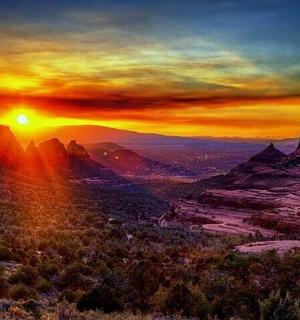 a painting of a sunset in the mountains