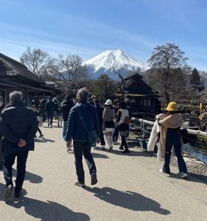 一群人走在街上,背景是一座山