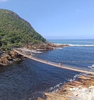 two people walking on a bridge over a body of water