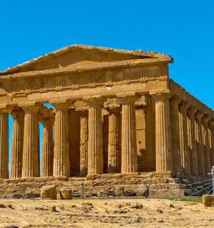 an ancient temple with columns on a hill