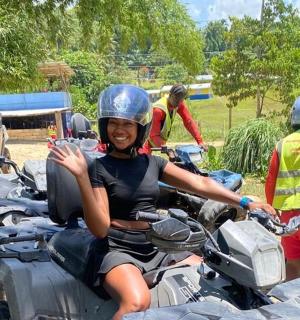 a woman waving while sitting on a motorcycle