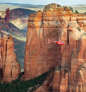 a red plane flying over the grand canyon
