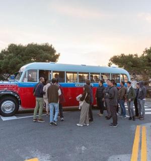 skupina lidí stojících před autobusem