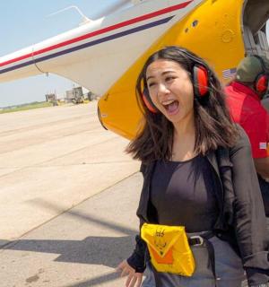 a woman is standing in front of a plane