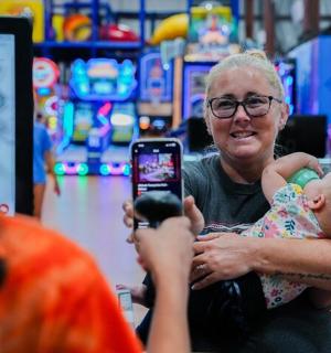 一名女子正在为一名抱着婴儿的女子拍照
