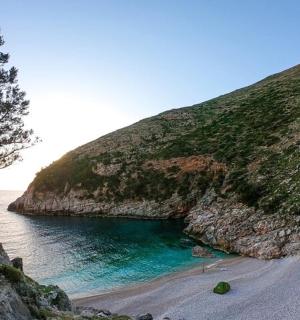 a beach with the ocean and a cliff