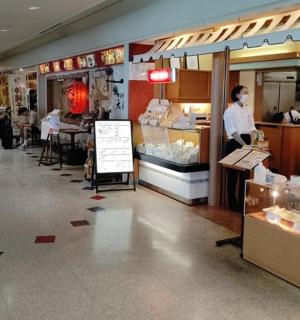 a store with a woman standing in the front of a bakery