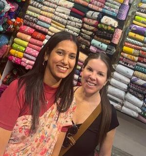 two women standing next to each other in a clothing store